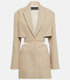 Woman wearing a beige cut-out blazer dress with V-neck, long sleeves, and tailored fit. Side cut-outs and single-button closure complete the chic design.
