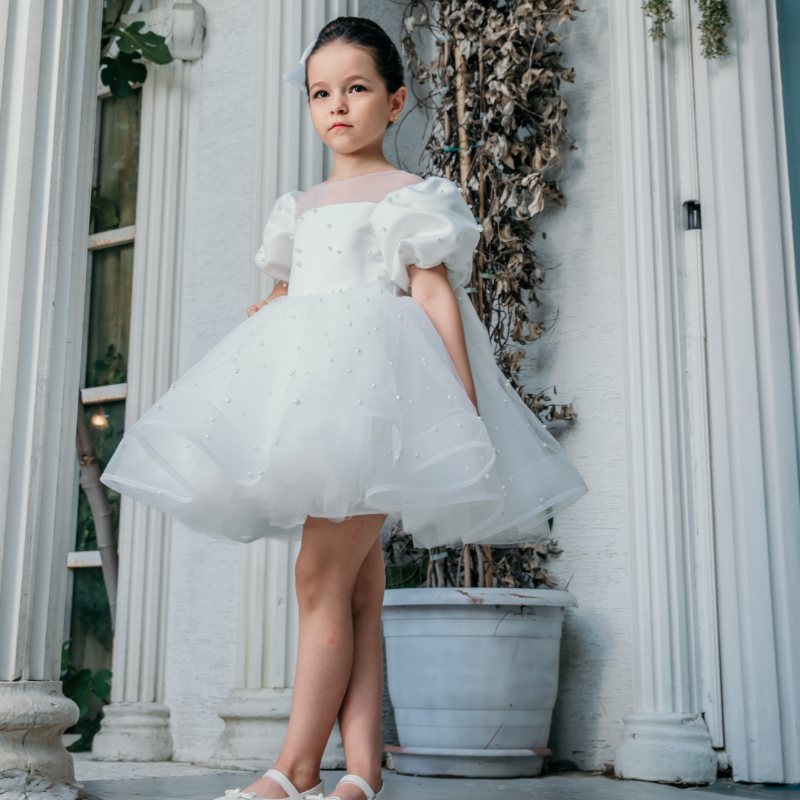 Little girl wearing ‘Angel Grace’ luxury baptism dress at a wedding, elegant and timeless special occasion outfit.