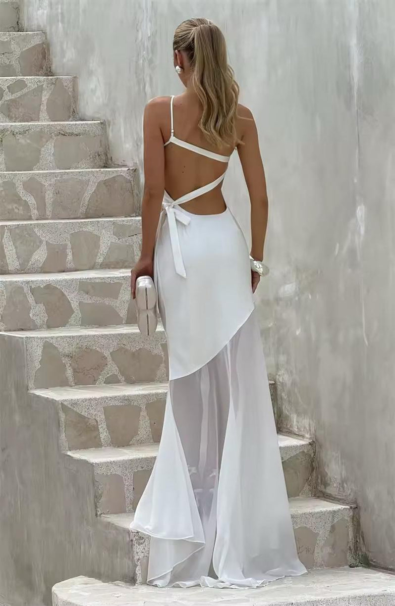 Model in white backless dress with long flowing hem and bow-tie detail – chic bridal or evening look
