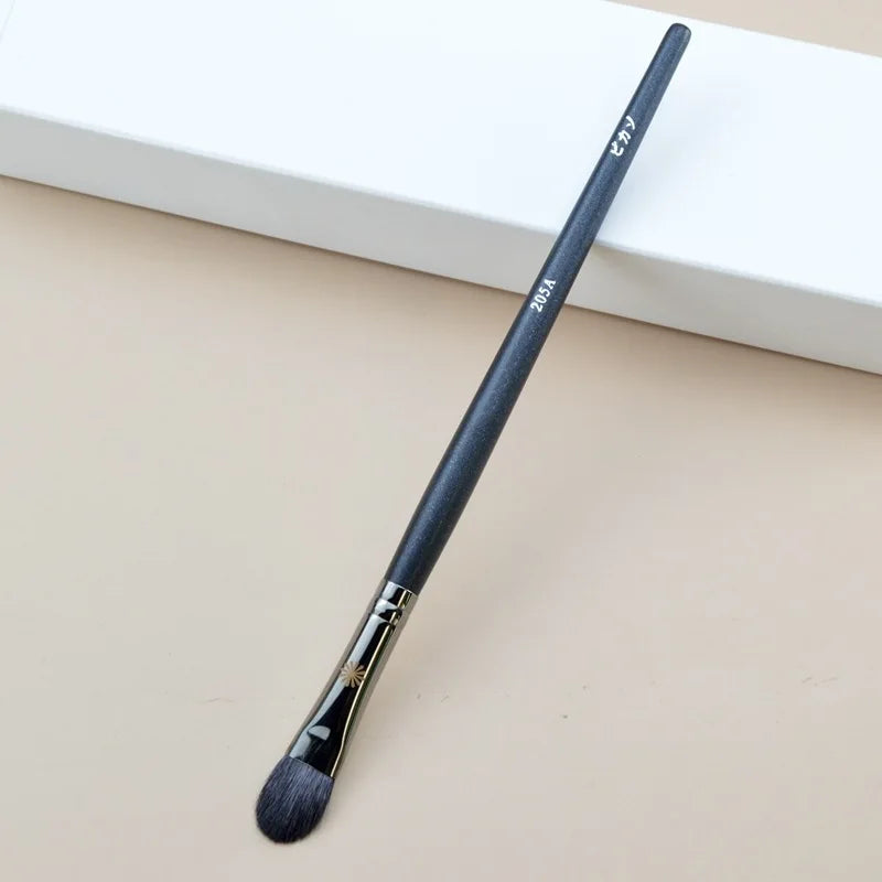 Makeup brush with an elegant design featuring a wooden handle and high-quality hairs for perfect makeup applications. Ideal for blusher, concealer, and eyeshadow.