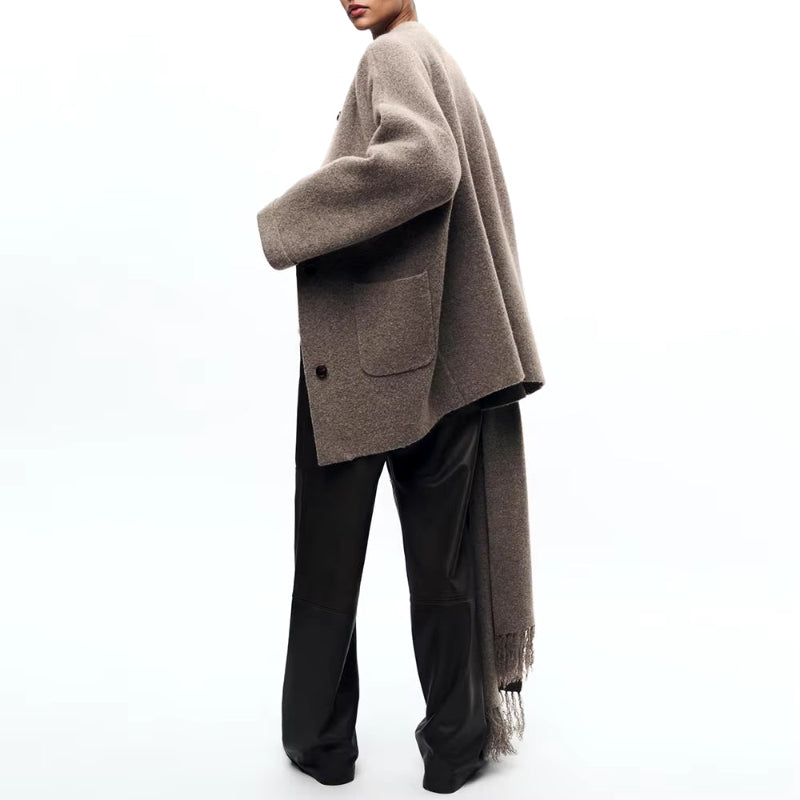 Elegant beige wool blend coat with attached scarf, single-breasted design and oversized silhouette for fall winter 2025.