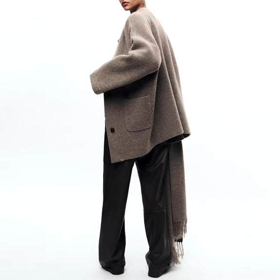 Elegant beige wool blend coat with attached scarf, single-breasted design and oversized silhouette for fall winter 2025.