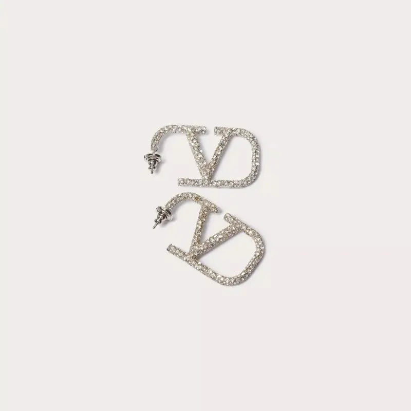 Elegant V-shaped earrings made of 18 karat gold-plated material, featuring sparkling Zirkonia stones for a luxurious, diamond-like shine. Perfect for everyday wear or special occasions, these medium-sized earrings with a modern V design add a sophisticated touch to any outfit.