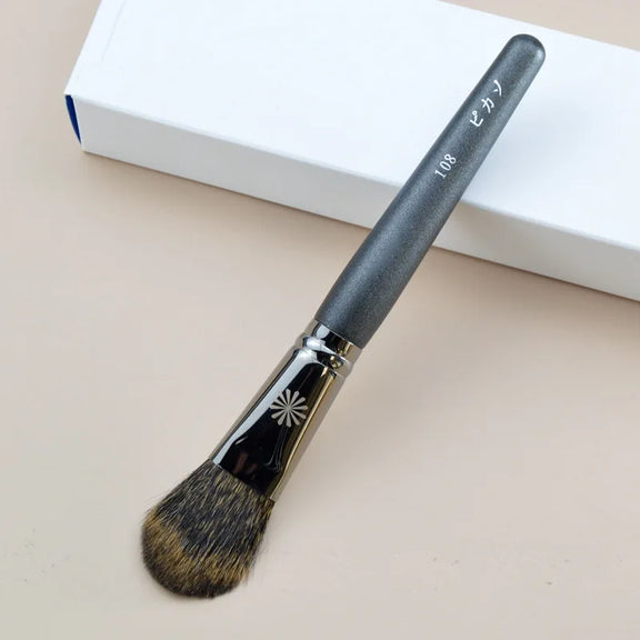 Makeup brush with an elegant design featuring a wooden handle and high-quality hairs for perfect makeup applications. Ideal for blusher, concealer, and eyeshadow.