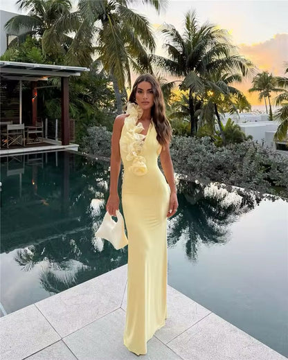 Noa yellow halter dress 2025 – floor-length backless gown with ruffle neckline, A-line silhouette, soft stretch polyester-spandex fabric. Elegant summer outfit for beach weddings, club nights, luxury vacations & golden hour events.