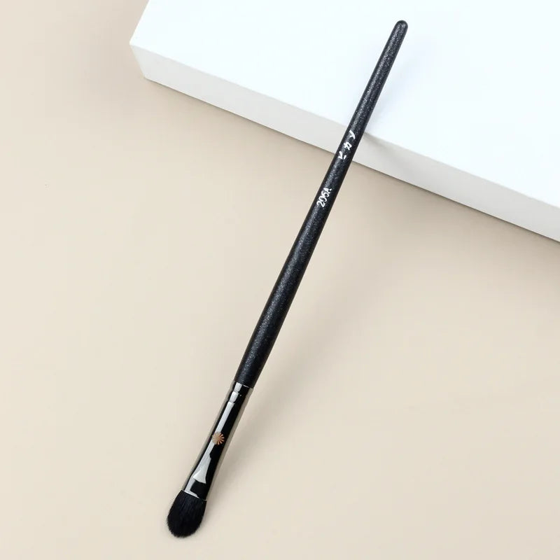 Makeup brush with an elegant design featuring a wooden handle and high-quality hairs for perfect makeup applications. Ideal for blusher, concealer, and eyeshadow.