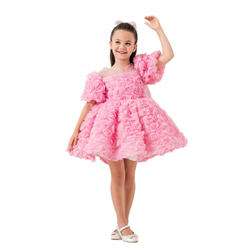 Child twirling in ‘Aurora Rose’ dress, capturing the flow of the knee-length pink tulle skirt.