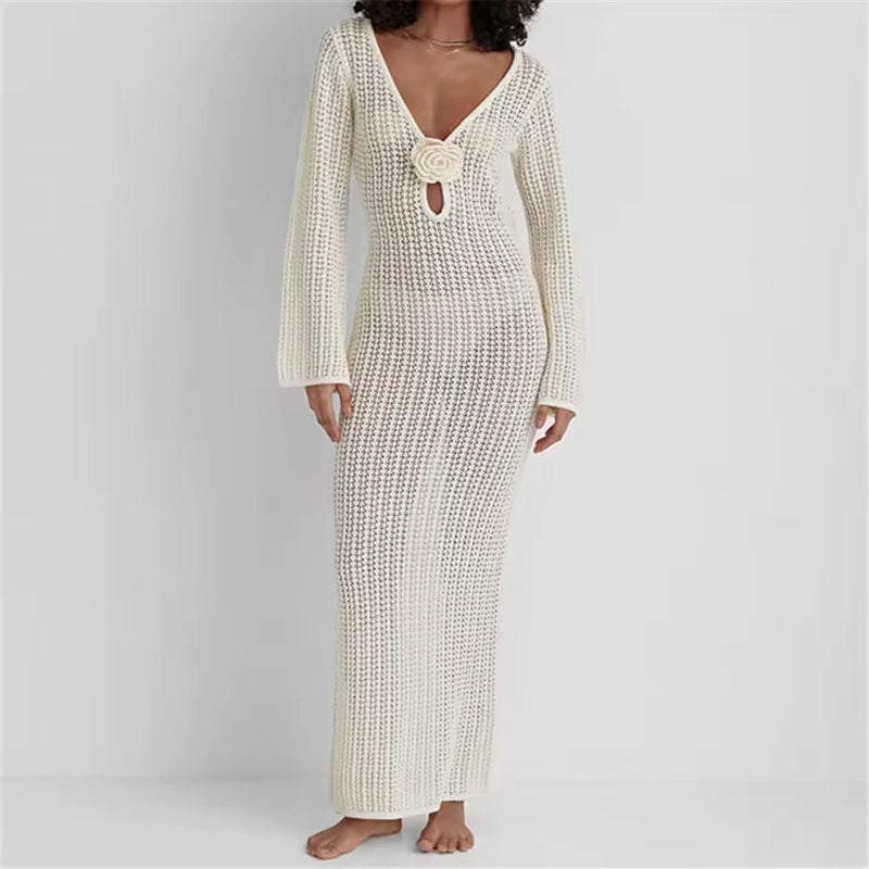 Woman wearing an ivory crochet maxi dress with a rose applique and deep V neckline – elegant boho beach style