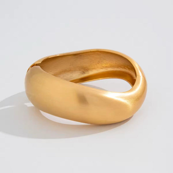 BoldCuff – sculptural matte gold bracelet with wide, architectural design for modern unisex style.
