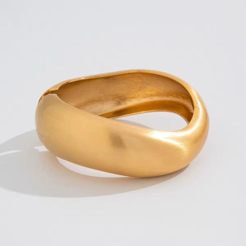 BoldCuff – sculptural matte gold bracelet with wide, architectural design for modern unisex style.
