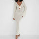 Back view of a backless ivory crochet dress with open knit design and tie-neck closure – summer vacation outfit