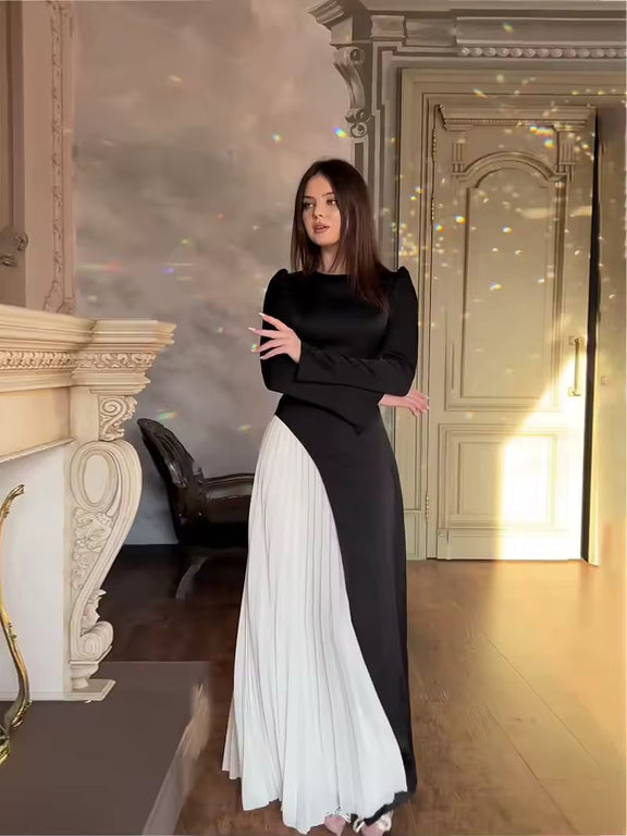 Full-length black and white dress for special occasions, modern formal wear with contrast pleats.
