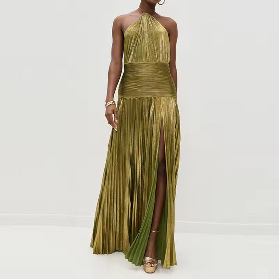 Model wearing a shimmering gold-olive pleated halter neck maxi dress with high slit and ruched waistband, styled with gold jewelry and platform heels – front view.