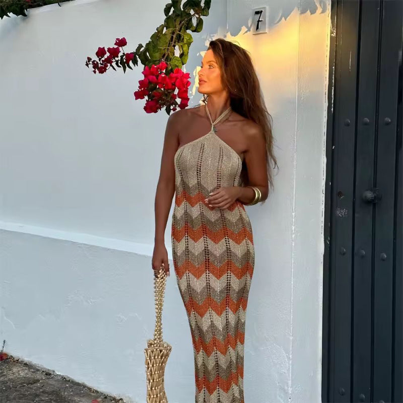 Model in sleeveless crochet summer dress “Palma” with chevron design, holding woven bag next to blooming bougainvillea
