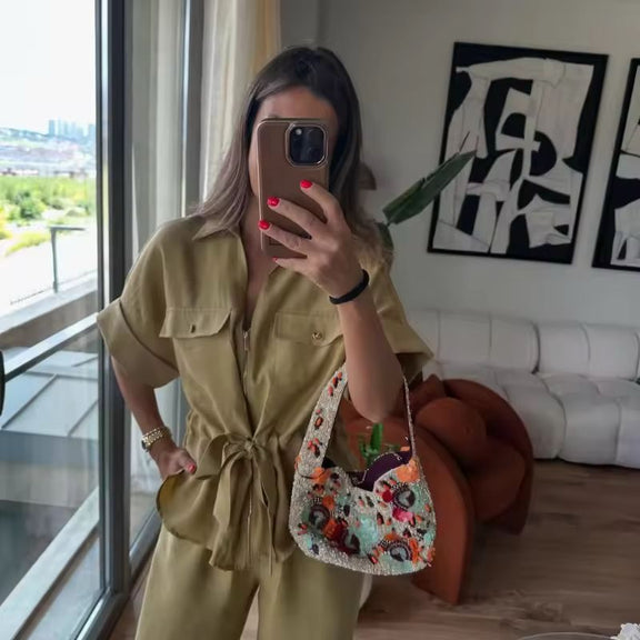 Woman wearing beige two-piece set with wide leg pants and belted shirt in premium fabric
