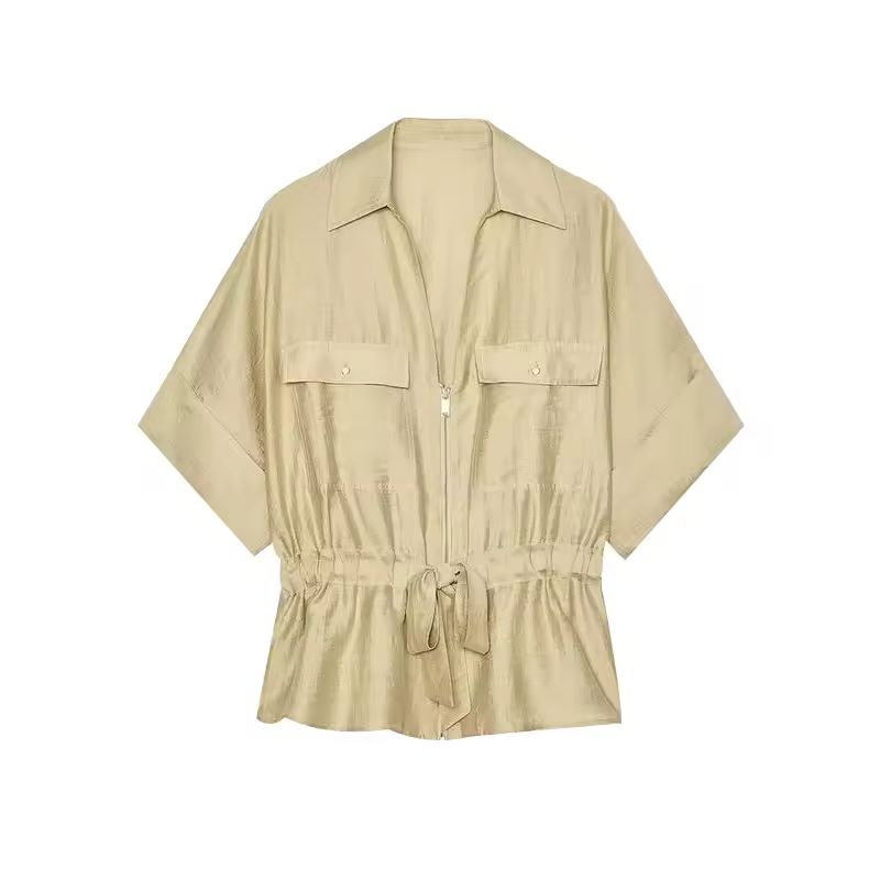 Woman wearing beige two-piece set with wide leg pants and belted shirt in premium fabric
