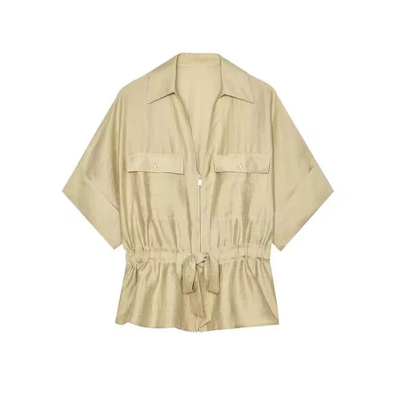 Woman wearing beige two-piece set with wide leg pants and belted shirt in premium fabric
