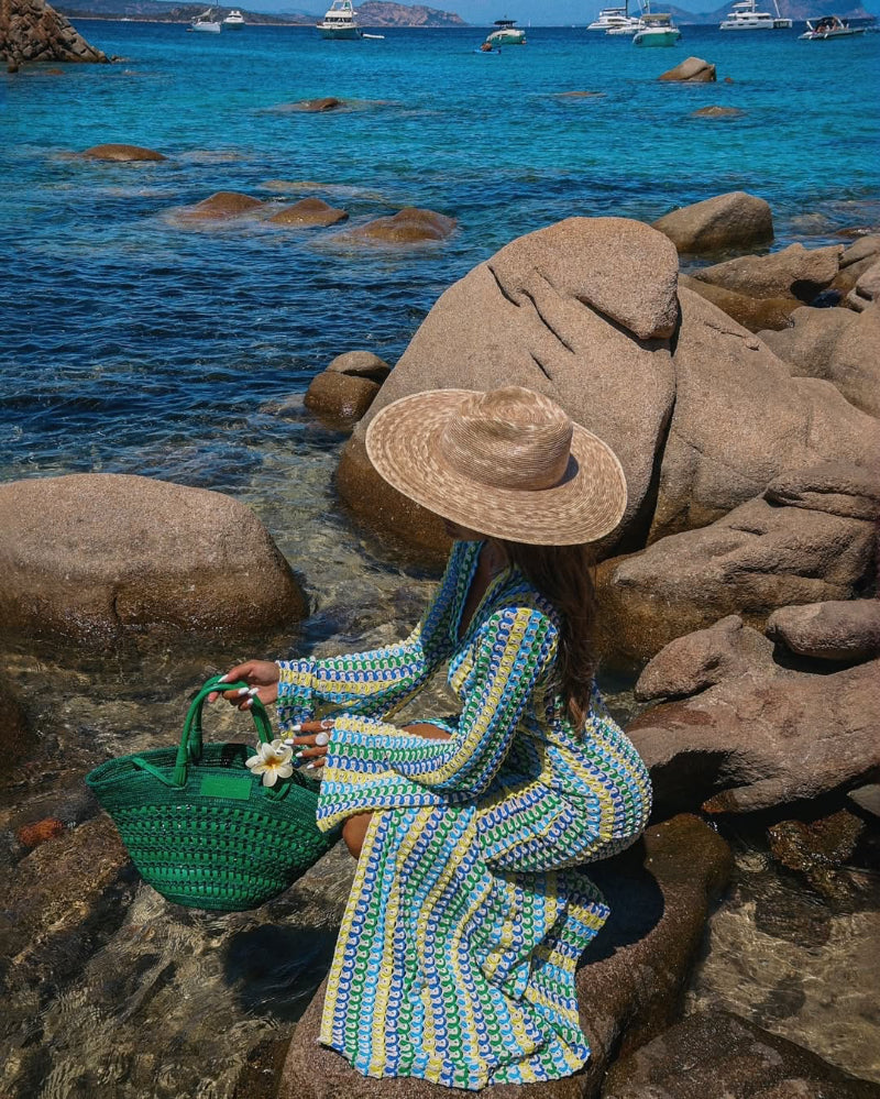 Seaside summer style – patterned dress, straw sun hat, and woven tote bag