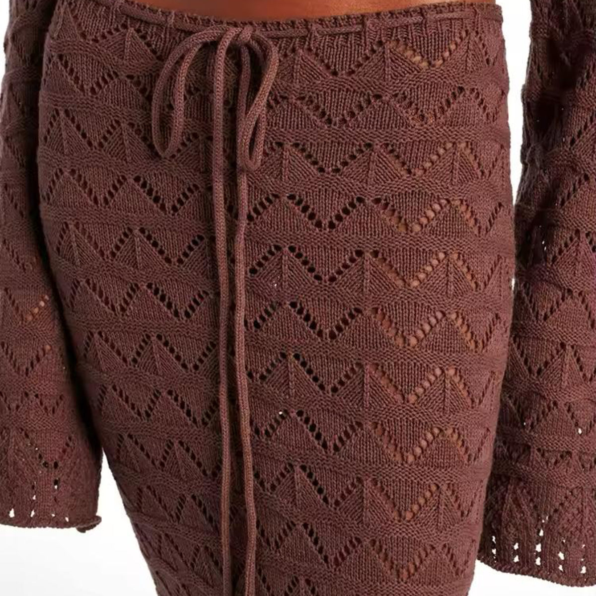 Close-up of Sahara Boho high-waisted maxi skirt with adjustable drawstring and side slit, showcasing lightweight crochet fabric in white and brown.