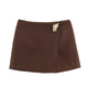 Chocolate brown high-waist wool-blend mini skirt with gold detail – elegant winter outfit for women.

