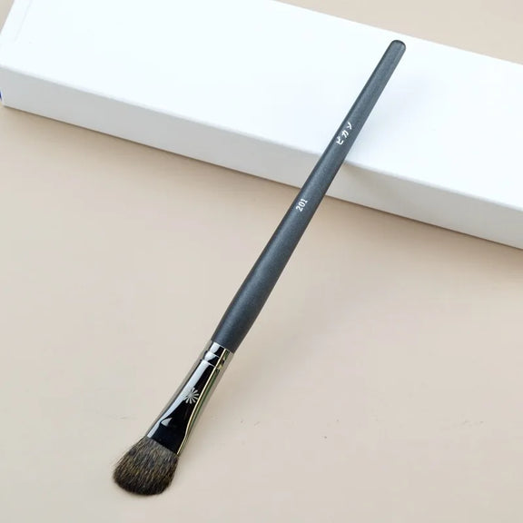 Makeup brush with an elegant design featuring a wooden handle and high-quality hairs for perfect makeup applications. Ideal for blusher, concealer, and eyeshadow.