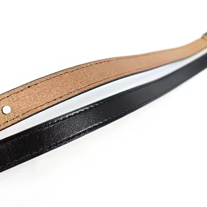Minimalist black genuine leather belt with gold-tone script buckle, high fashion style
