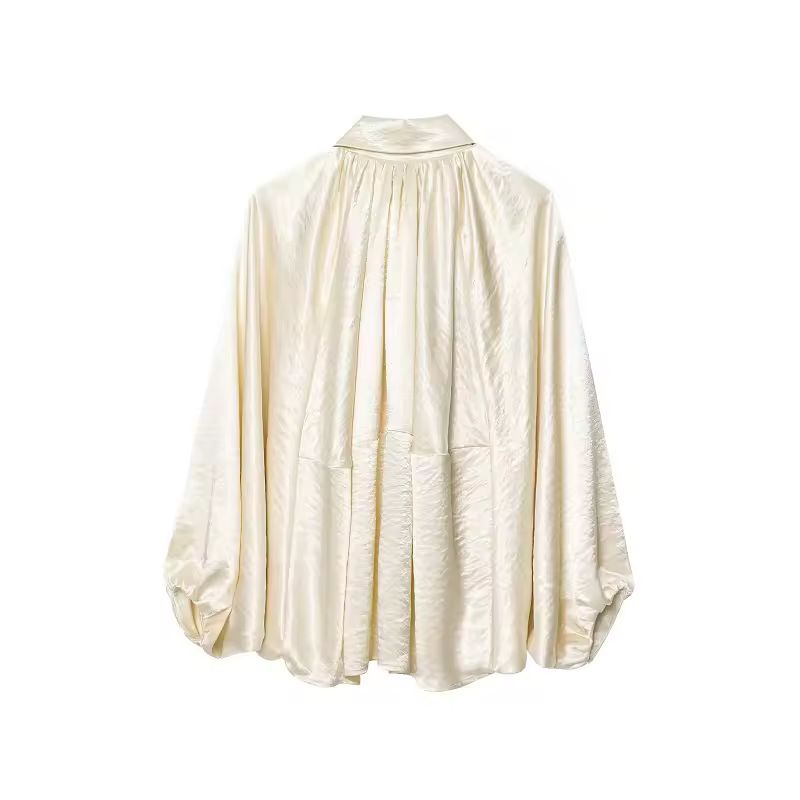 Champagne ivory satin‑feel blouse with turn‑down collar and statement sleeves