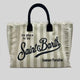 Extra-large Saint Barth canvas beach bag for women with boho fringe and summer script, oversized and handcrafted look.
