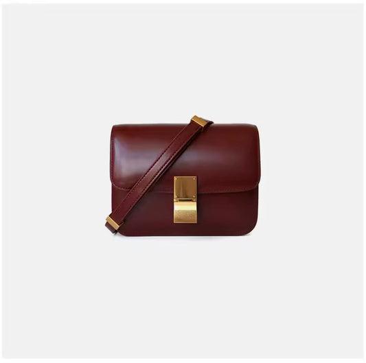 Elegant burgundy genuine leather shoulder bag with gold clasp and adjustable strap — timeless minimalist handbag for everyday wear.
