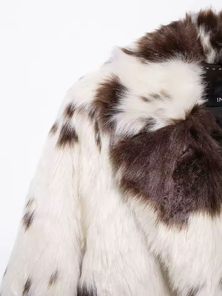 Close-up texture of soft brown and white faux fur material on women’s coat
