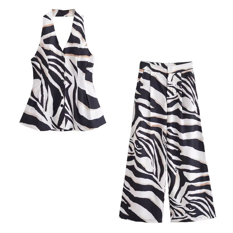 Woman wearing a black and white zebra print two-piece set featuring high waist palazzo pants and a sleeveless V-neck buttoned top.
