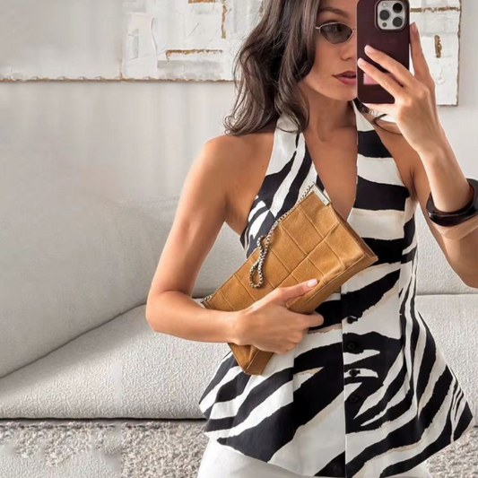 Trendy zebra print two-piece outfit for women, styled outdoors with wide-leg pants and sleeveless buttoned top, ideal for summer fashion.
